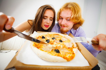 Funny couple eating pizza