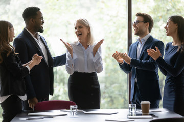 Overjoyed diverse businesspeople applaud celebrate company business success at meeting together,...