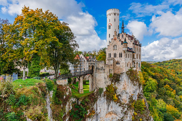 Germany, Lichtenstein Castle in Baden-Wurttemberg land in Swabian Alps. Seasonal view of Lichtenstein Castle on a cliff circled by trees with yellow foliage. European famous landmark.