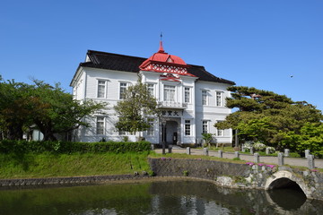 Fototapeta na wymiar 赤いドームの大宝館 ／ 山形県鶴岡市にある大宝館は、大正天皇の即位を記念して、大正４年(1915)に建てられた、赤いドームと白壁が特徴の、完成度の高い擬洋風建築です。開館当初は、物産陳列場、戦後は市立図書館として利用されていました。現在は、明治の文豪・高山樗牛や、日本のダ・ヴィンチといわれた松森胤保、昭和初期の日本の代表作家・横光利一など、鶴岡が生んだ先人たちの偉業を讃える資料を展示しています。