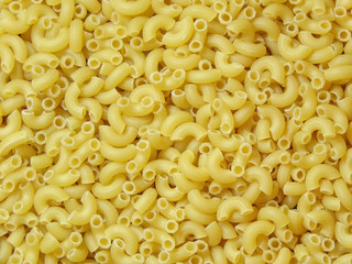Macaroni background. Raw macaroni close- up top view. Dry ingredients for cooking. Pasta. Copy space. Abstract background. Cooking and cuisine. Background for the design.