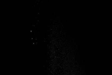 Started splash of white flour powder on black background.