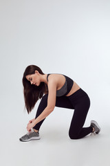 woman in sportswear tying shoelaces
