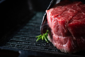 Chef roasts filet Mignon beef steak in a pan with tongs