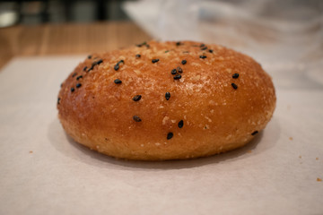 Curried bread bun with black sesame seeds in a bakery cafe.