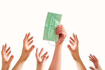 A hand hold a face mask with many hands try to grab or capture , shortage or surging high demand of...