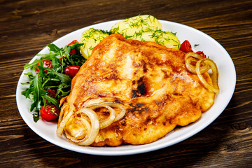 Schnitzel with boiled potatoes on timber background