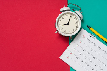 close up of calendar and alarm clock on the table, planning for business meeting or travel planning concept