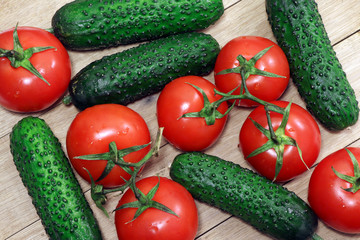 Tomatoes and cucumbers on a wooden table. Healthy, vegetarian food. Natural food.Vegetables on a table. Flat lay.