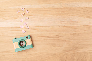 Flat lay with toy wooden camera and hearts. Social media, posts, likes, followers, online photography classes concept. Top view