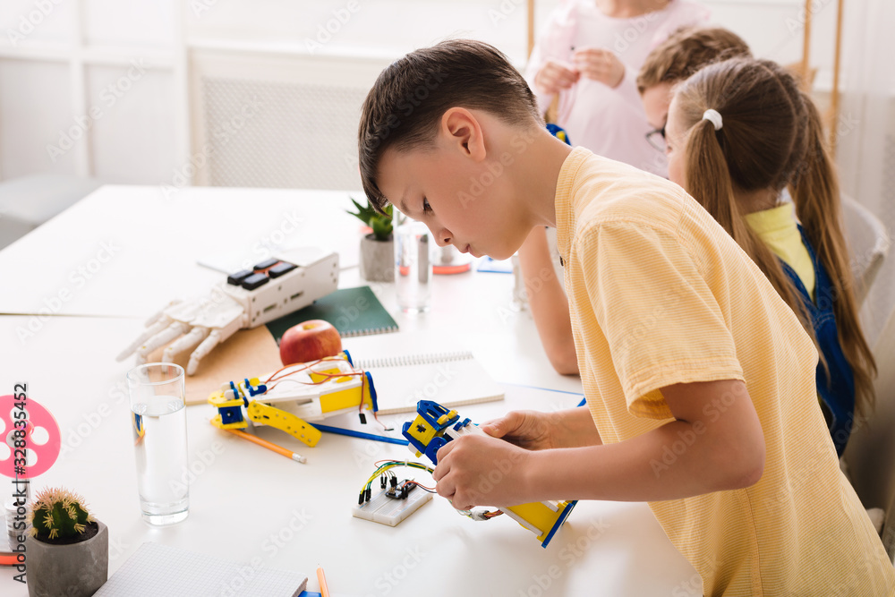 Poster Modern technology concept. Boy creating robot at stem class