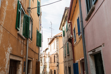 Fototapeta na wymiar Travel summer concept. Old city view of Europe, Croatia, Istria region, Rovinj. Empty street with old buildings with shutters.