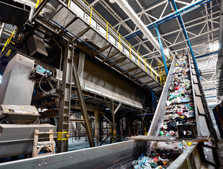 GRODNO, BELARUS - OCTOBER 2018: recycling plant conveyor belt transports garbage inside drum filter...