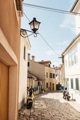Obraz premium Travel summer concept. Old city view of Europe, Croatia, Istria region, Rovinj. Empty street with old buildings and motorbikes at sunny day.