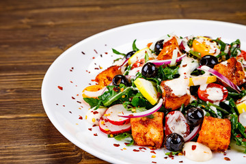 Fried chicken breast and vegetables on wooden table