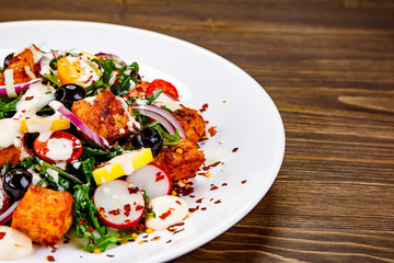 Fried chicken breast and vegetables on wooden table