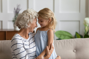 Happy mature grandmother hug embrace enjoy family moment with cute little preschooler...