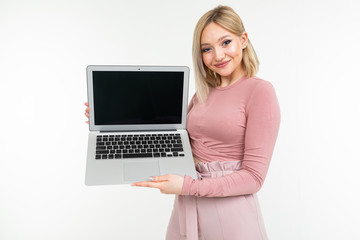 European stylish young woman shows a laptop display with a layout for the site on a white background