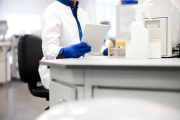 Research scientist in sterile gloves holding digital tablet
