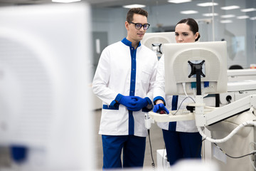 Fototapeta premium Research scientists using automated immunoassay system in lab