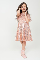 Full-length teenager girl in shiny party dress posing on a white studio background