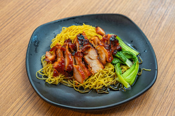 Plate of delicious Chinese honey grilled pork noodles- char siew