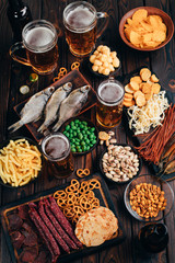 Two mugs of light beer and selection of beer snacks on the table. Oktoberfest food, pub concept