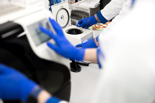 Research scientists using advia immunoassay system in lab - Powered by Adobe