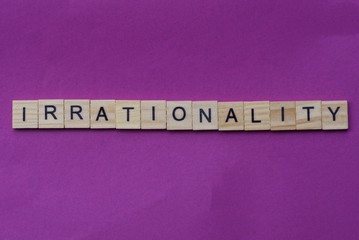  word irrationality from small gray wooden letters lies on a lilac background