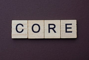 gray word core from small wooden letters on a brown table