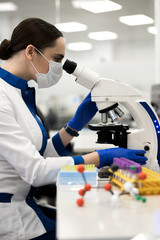 Female scientist working with microscope in laboratory