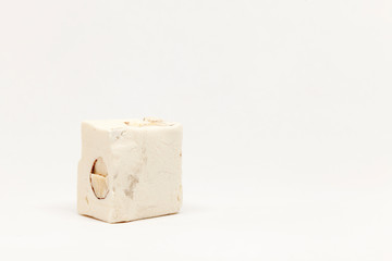 a piece of white nougat candy on light background