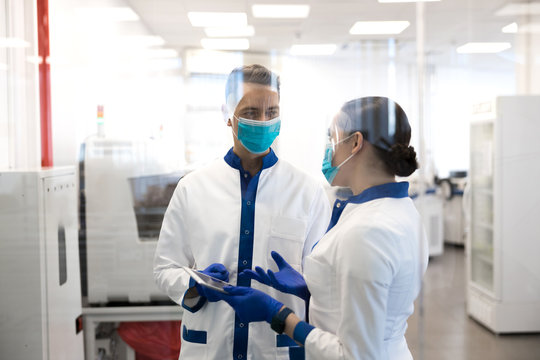 Two scientists discussing medical research in laboratory