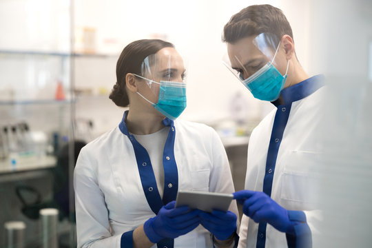 Research scientists using digital tablet in laboratory