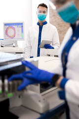 Researcher in protective medical mask working in laboratory