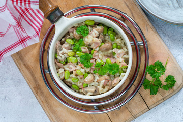 Bacon and mushroom risotto with edamame beans in a saucepan - overhead view