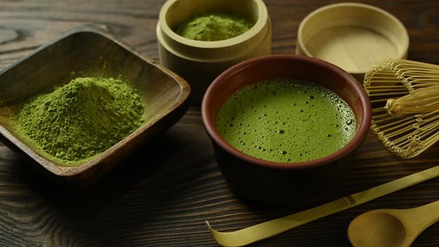 matcha tea with a cup stands on a wooden table