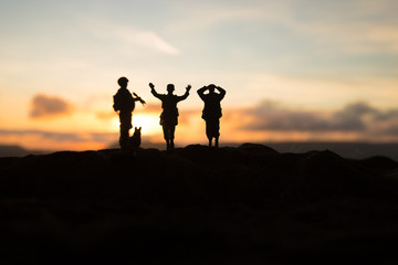 Battle scene. Military silhouettes fighting scene on war fog sky background. A German soldiers raised arms to surrender.