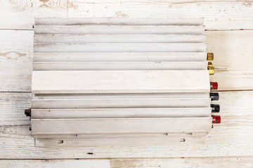 Old white 12v power amplifier on wood floor, hi grade grade technology