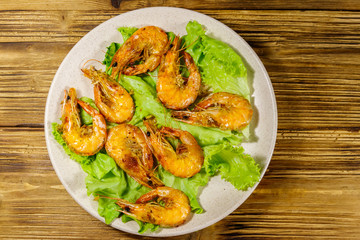 Tasty baked shrimps on a wooden table. Top view