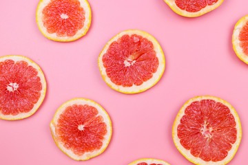 Slices of grapefruit on a pink background