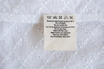 laundry care washing instructions clothes label on fabric texture background