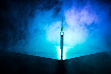 Medical syringe on wooden table with toned foggy background. Creative artwork decoration