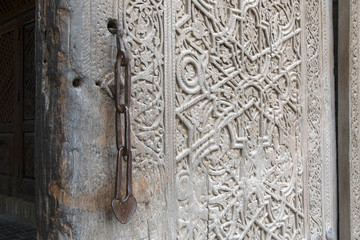 Old wooden door (with chain lock) of zindan (prison) in Kuhna Ark fortress. Khiva, Uzbekistan.