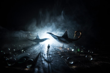 Silhouette of a man standing in the middle of the road on a misty night with giant Antique Aladdin...