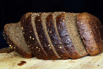 pieces of brown tommy sprinkled with coriander   lie on a cutting board. Black background. Concept - healthy eating, vegan, diet