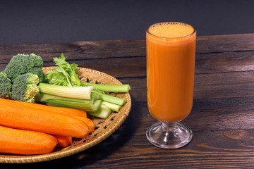 Fresh carrot juice. Vegetables on a wooden table.  Healthy, vegetarian food. Natural vitamins. Carrot, broccoli and celery.  