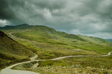 Fototapeta na wymiar Cycling mountain road. Misty mountain road in high mountains.. Cloudy sky with mountain road
