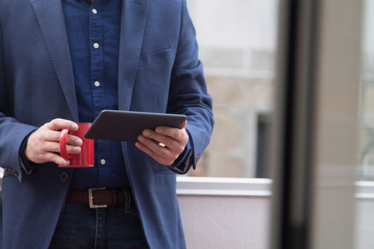 man using tablet while having coffee