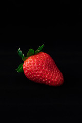 Strawberry with strawberry leaf on black background